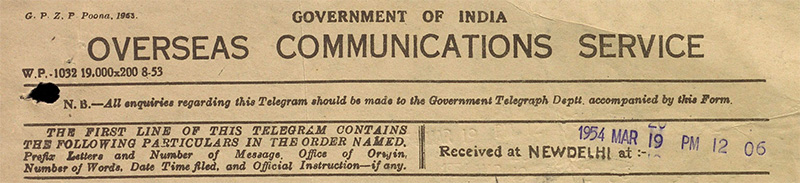 A telegram header from the Government of India Overseas Communications Service. It includes form numbers, instructions for handling, and a timestamp marking receipt at New Delhi. The text is in a typewriter font on aged paper, featuring a blue stamp with the date and time.